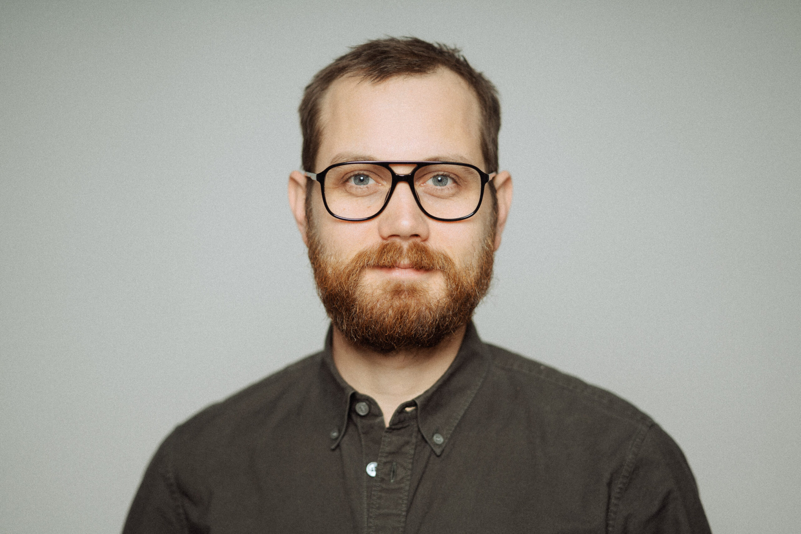 Portrait von Kilian Zagel vor einem hellgrauen Hintergrund.