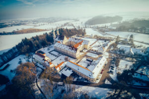 Kloster Holzen im Winter. Eine eindrucksvolle Luftaufnahme die das Kloster zeigt. Blick über das Lechtal.